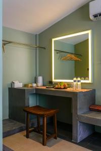 un comptoir dans une pièce avec un miroir et un tabouret dans l'établissement Maiiam Bungalows Kata Beach, à Kata Beach