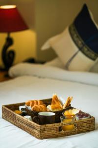 a tray of bread and pastries on a bed at Ambassador Hill in Yangon