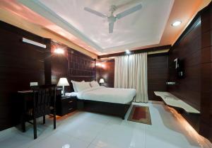 een slaapkamer met een bed, een bureau en een plafond bij Sun - A TAJ VIEW HERITAGE HOTEL in Agra