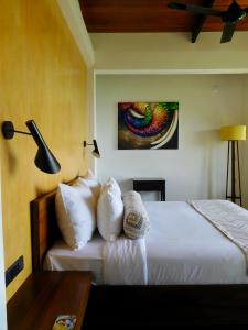 1 dormitorio con 1 cama y una pintura en la pared en GlenMyu Estate, en Haputale