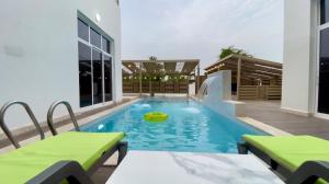 a swimming pool with a yellow frisbee in it at La Vida Inn in Ḑibāb