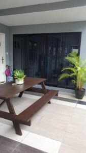 詩巫的住宿－Family Holiday House @Civic Centre Dewan Suarah，木餐桌,在种植了盆栽植物的房间里