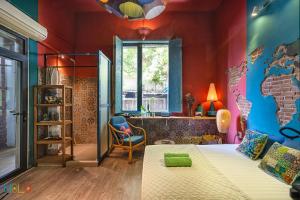 een slaapkamer met een bed en een kamer met een wereldmuurschildering bij HoLo Bato Saigon - Serviced HomeStay in Ho Chi Minh-stad