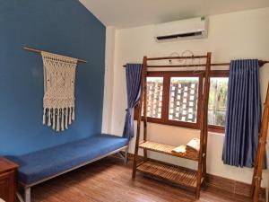 a room with a blue wall with a bench and a window at Ong Lang Bay Resort in Phú Quốc
