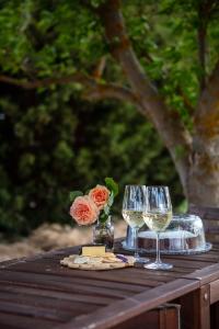 Springton的住宿－Meander Retreat - The Green Room，一张桌子,上面放着两杯葡萄酒和一朵花