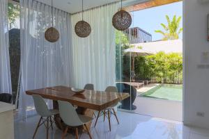 a dining room with a wooden table and chairs at Вилла Vista Del Mare in Koh Samui