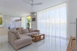 a living room with a couch and a table at Вилла Vista Del Mare in Koh Samui