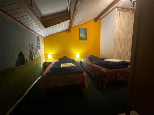 two beds in a room with yellow walls at LA DRYADE 