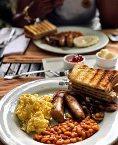 - une assiette de petit-déjeuner avec des saucisses, des haricots et du pain grillé dans l'établissement Sapphire Residences by Crystal, à Ikeja