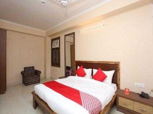 a bedroom with a large bed with red pillows at OYO Flagship Grand Aashirwad in Ghaziabad
