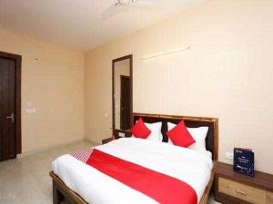 a bedroom with a large bed with red pillows at OYO Flagship Grand Aashirwad in Ghaziabad