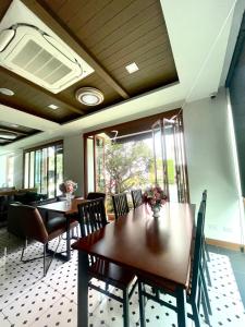 uma sala de jantar com uma mesa de madeira e cadeiras em Baannalin Hometel บ้านนลิน โฮมเทล em Chiang Mai