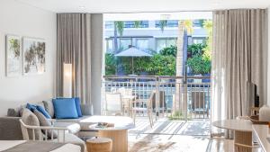 a living room with a couch and a large window at Oaks Casuarina Santai Resort in Kingscliff