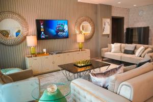 een woonkamer met banken en een flatscreen-tv bij Royal Club By RVHR, Palm Jumeirah in Dubai