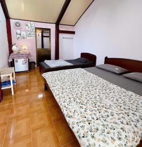 um quarto com 2 camas e piso em madeira em Mai Anh Homestay Long Hải em Long Hai