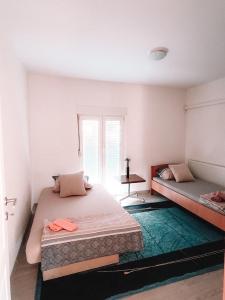 a bedroom with two beds and a window at Poseidon House in Mostar