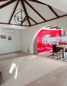 a living room with a table and a red wall at Poseidon House in Mostar