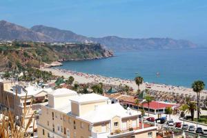 a view of a beach with a lot of people at Bonito piso a 300m de la playa Nerja in Nerja