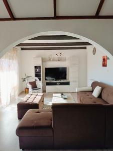 a living room with two couches and a flat screen tv at Poseidon House in Mostar