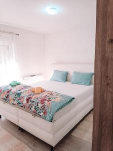 a bedroom with a large white bed with blue pillows at Poseidon House in Mostar