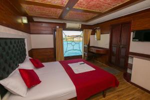 a bedroom with a large bed with a large window at Angel Blue Houseboat Alapuzha in Alleppey