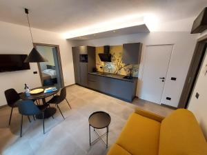 sala de estar con sofá amarillo y mesa en ApartmentsGarda - Residenza Garda Deluxe, en Garda