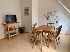 a dining room with a table and chairs and a tv at Wohnen am Wasserschloss Sandizell in Schrobenhausen