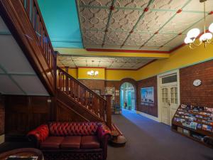 a living room with a couch and a staircase at YHA Newcastle Beach in Newcastle