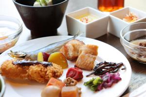 Hotel JAL City Nagoya Nishiki في ناغويا: طبق من الطعام مع الأسماك وغيرها من الأطعمة على الطاولة