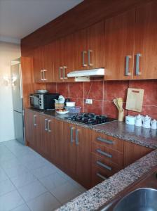 uma cozinha com armários de madeira, um fogão e um frigorífico em Appartement l’escala em L'Escala