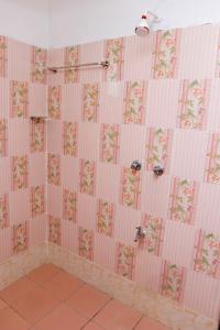 un bagno piastrellato rosa con parete di piastrelle rosa e bianche di Greenyard Resort Mtwapa a Mtwapa