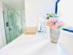 a vase filled with pink flowers sitting on a counter at Christchurch CBD Luxury townhouse in Christchurch +27 photos