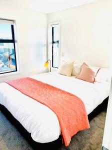 a white bedroom with two beds with a window at CHCH centre Luxury townhouse close to CBD in Christchurch