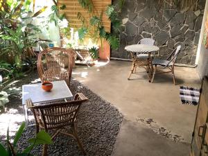 a patio with chairs and a table and a table and chairs at Fare Rearea à Papeete in Papeete