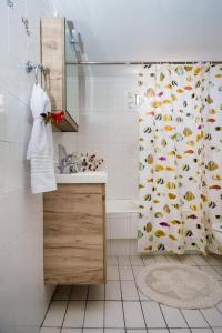 a bathroom with a shower curtain with fish on it at Rena’s house 2 in Argostoli