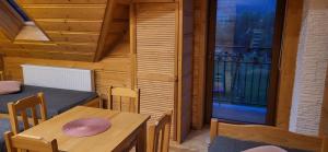 una sala da pranzo con tavolo e sedie e un balcone di Grazynka a Zakopane