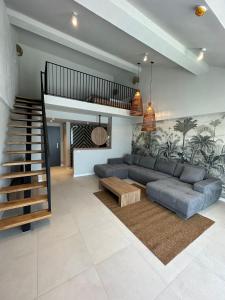ein Wohnzimmer mit einem Sofa und einer Treppe in der Unterkunft Luuma in 2 Mai