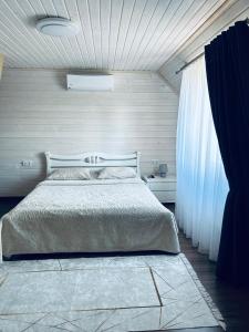 Un dormitorio con una cama grande y una ventana en Вілла Смерекова хата - Келечин 144 en Pilipets
