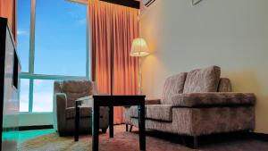 un soggiorno con divano, sedia e lampada di Pan Borneo Hotel Kota Kinabalu a Kota Kinabalu