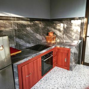 a kitchen with a black counter top and a refrigerator at Dewa Put Guest House in Ubud