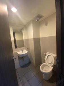 a bathroom with a toilet and a sink at apartemen bintaro icon in Pondokaren