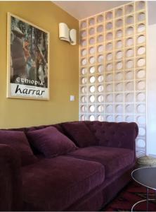a living room with a purple couch and a table at Apartamento renovado en Cadaqués in Cadaqués