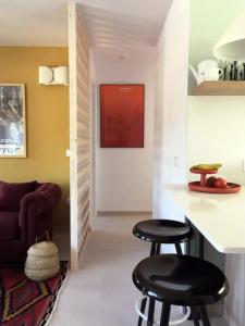 Apartamento renovado en Cadaqués في كاداكيس: غرفة معيشة مع كرسيين بار وأريكة