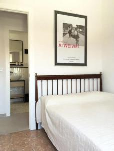 Apartamento renovado en Cadaqués في كاداكيس: غرفة نوم بسرير وصورة على الحائط