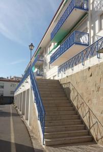 a set of stairs with blue railing next to a building at Apartamento renovado en Cadaqués in Cadaqués