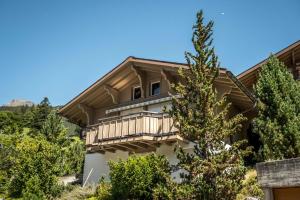 une maison avec un balcon sur le côté de celle-ci dans l'établissement Chalet Eiger View - GRIWA RENT, à Grindelwald