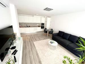 a living room with a black couch and a kitchen at West Budapest-Edge of Downtown-Free Parking in Budapest