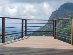 a wooden boardwalk with a view of a mountain at Ella Mount View Guest Inn in Ella