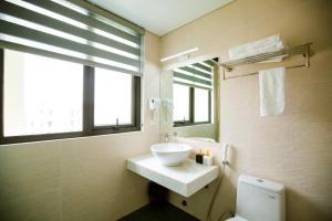 uma casa de banho com um lavatório, um WC e uma janela. em Lam Anh Hotel Him Lam Vạn Phúc Hà Đông em Hà Ðông