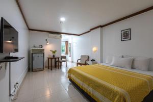 a hotel room with a bed and a television at Howard Square Boutique Hotel in Bangkok